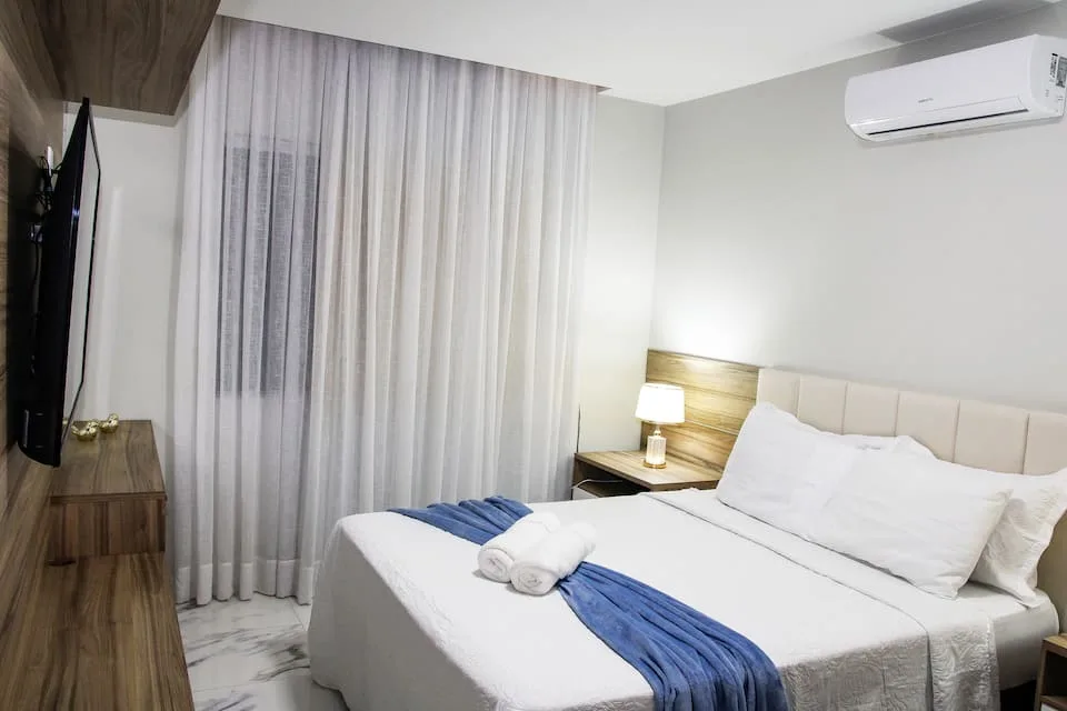 Suíte principal com cama queen e televisão